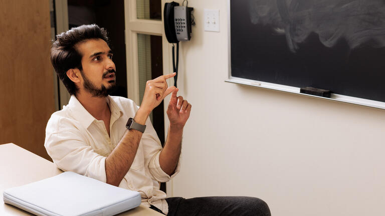 graduate student gestures with hands while speaking in class