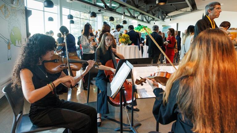 Students seated and playing string instruments