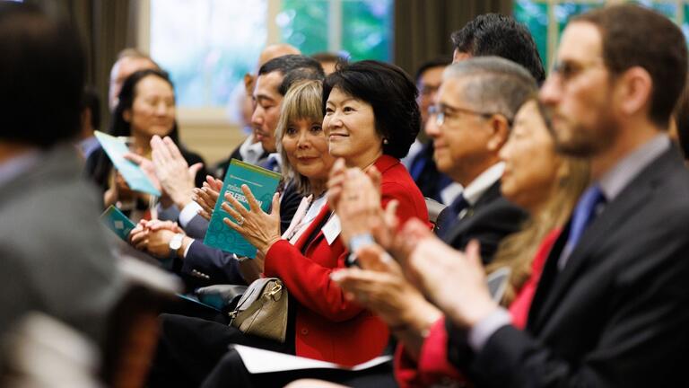 Attendees in crowd clapping