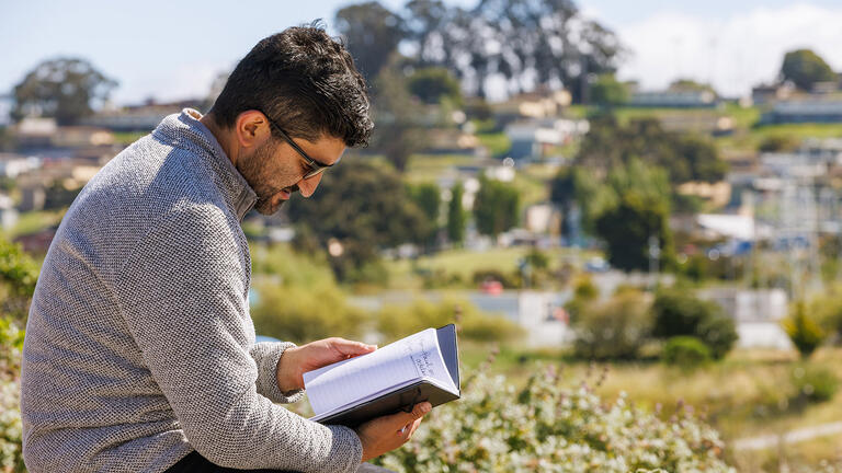 students looks down at notebook in San Francisco's Bayview neighborhood