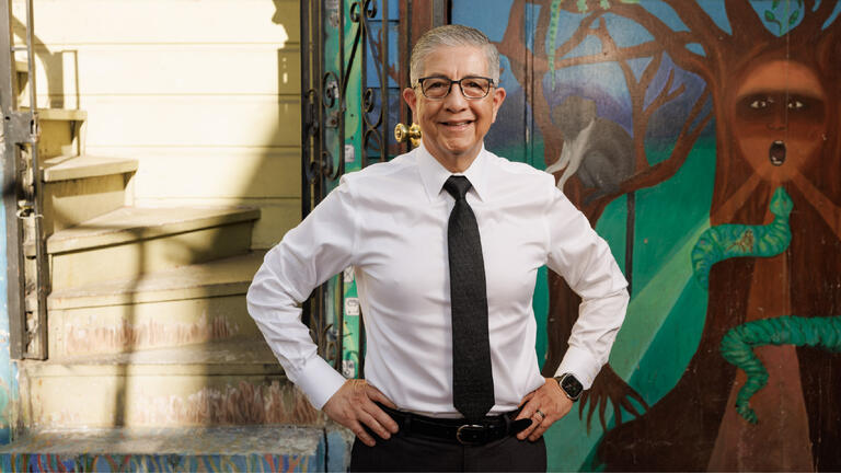 President Aceves standing in front of a mural
