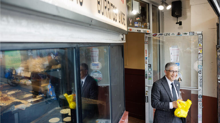 President Aceves exiting a bakery