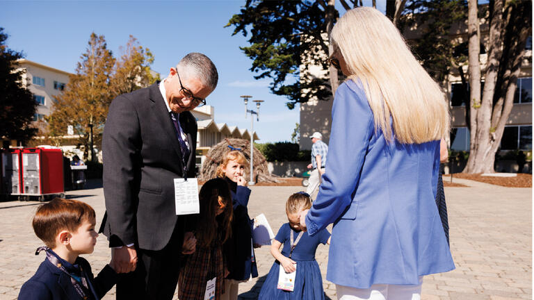 President Aceves walking with children