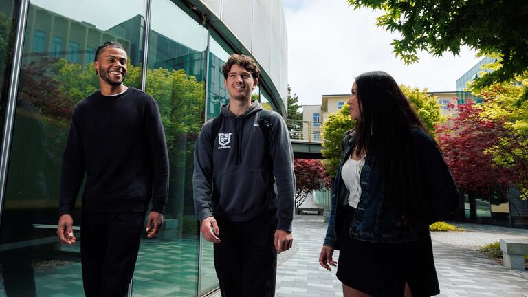 Three students walking and talking to each other