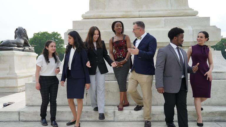 students and teacher go down the stairs