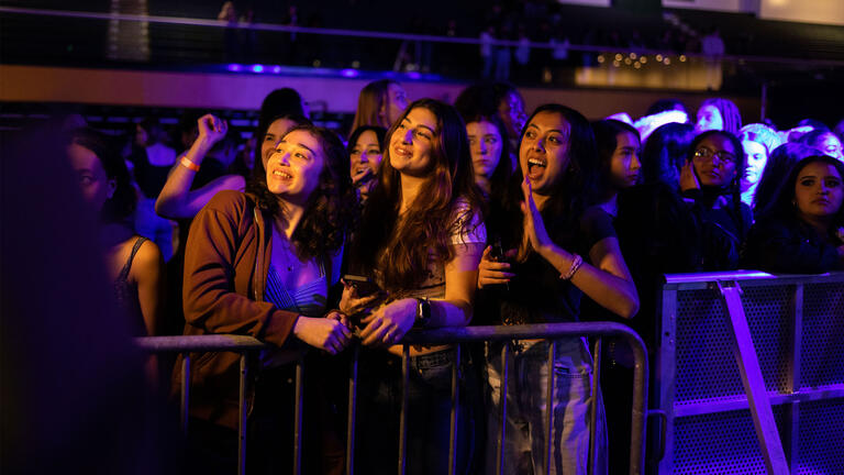 Three USF students smiling among a crowd of students at Donaroo