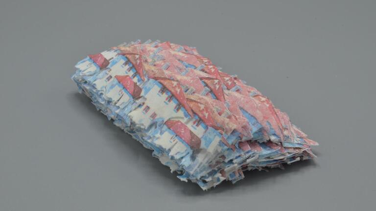 Layers of houses with red tile roofs cut from papertowels