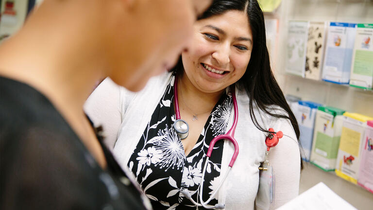 Nurse smiling and chatting with a colleague