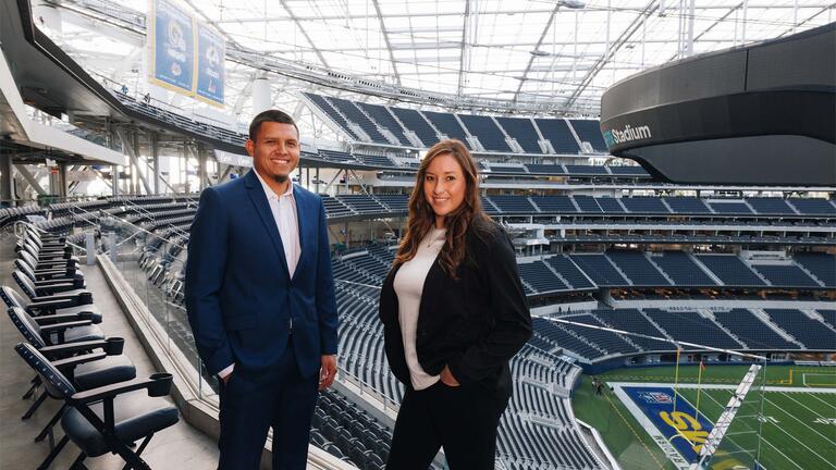 Two professionals standing in a stadium