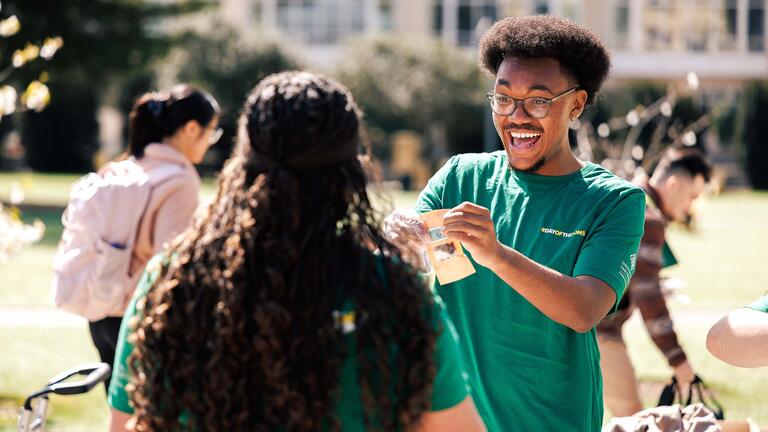 Volunteer handing out swag and smiling