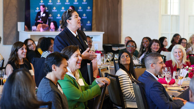 Woman standing asking a question at the WILP Symposium