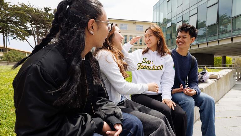 Four students sitting and talking to one another
