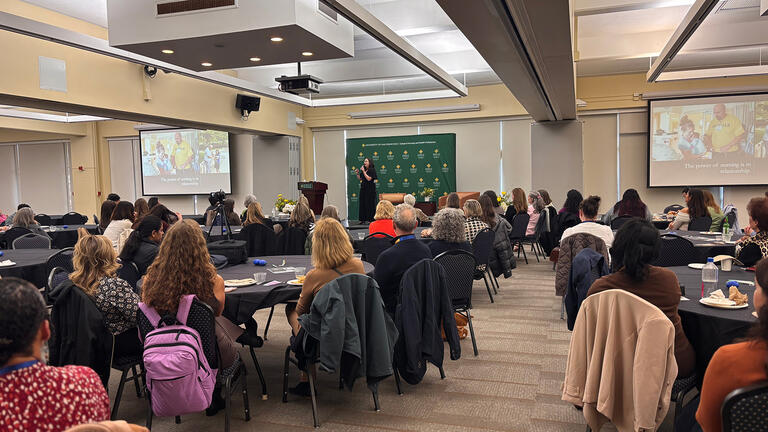A more zoomed out shot of Sarah DiGregorio speaking during event