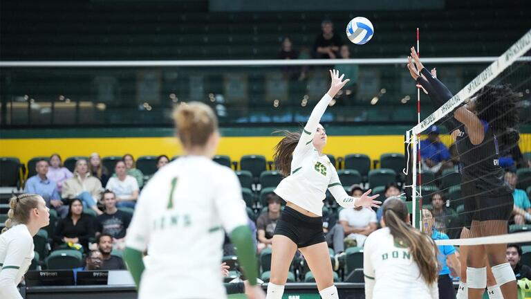 Womens volleyball player reaching for ball