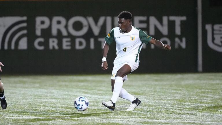 Mens soccer player kicking ball