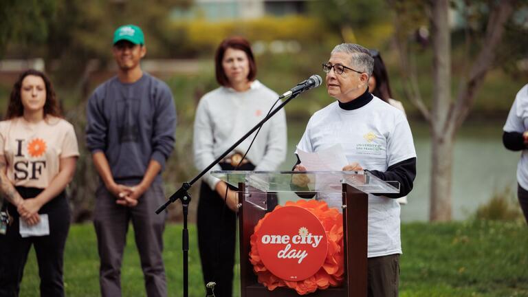 President Aceves speaking at the podium for One City Day