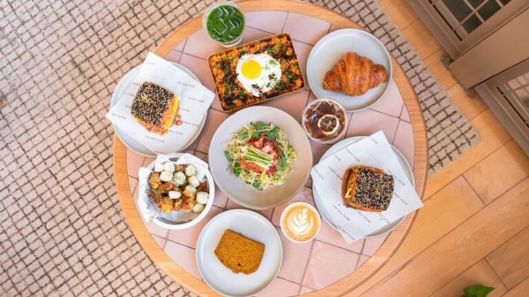 Birds eye view of a table with featuring an array of signature Korean-American dishes at Sōhn.