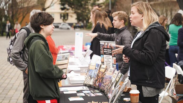 A student and a staff member talking at a fair