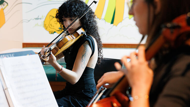 student plays instrument at event