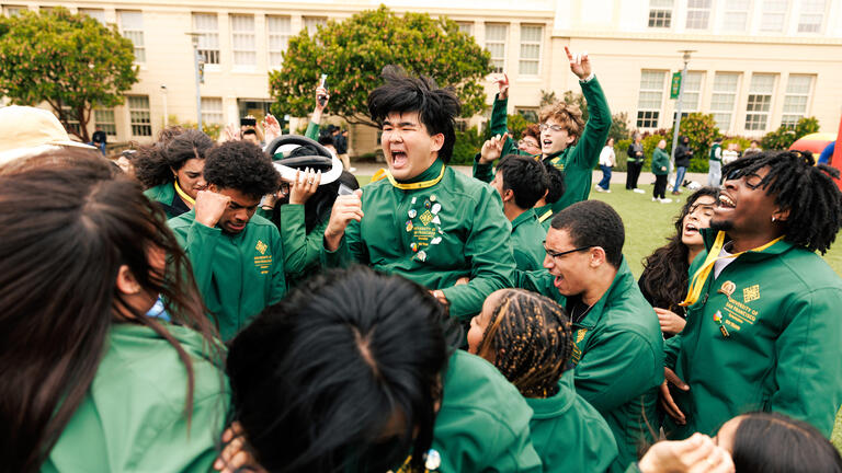 usf students dressed in green jumping up and down outside