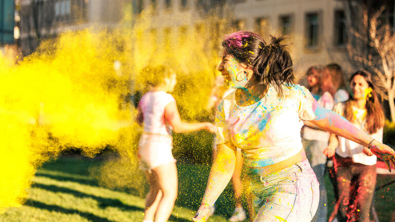 Students celebrating Holi in front of Gleeson Library