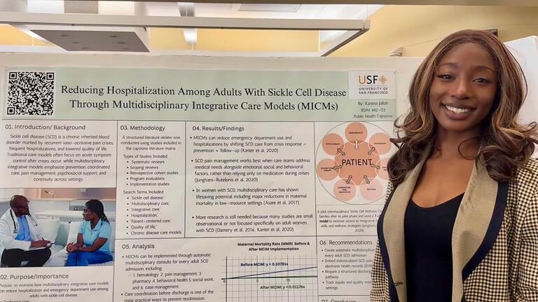 student stands in front of her research board at an event