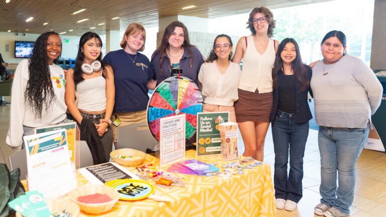 students stand in front of table that says USFVotes