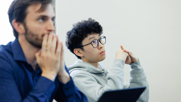 two applied economics students sit in class