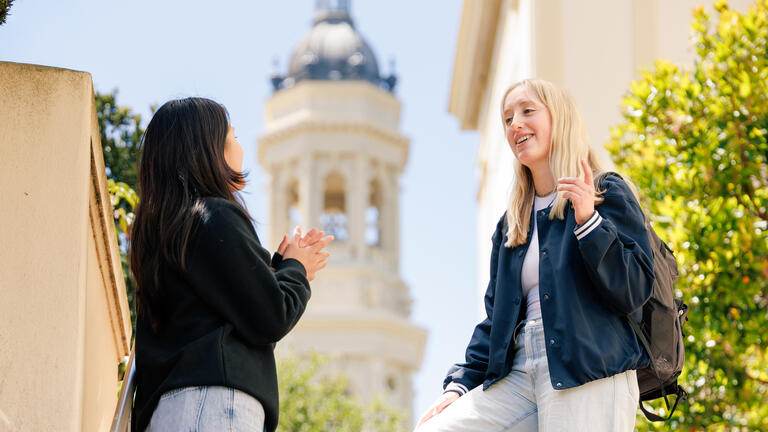 students talk outside with st.ignatius tower in background