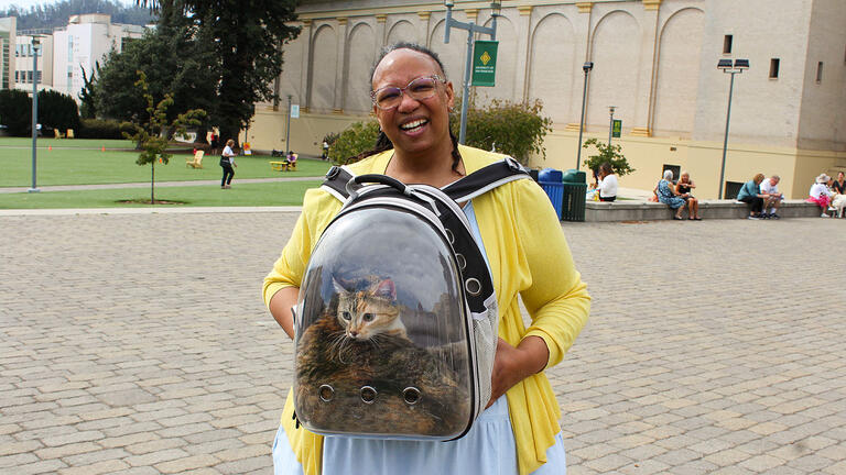 Owner standing with a clear backpack with cat inside