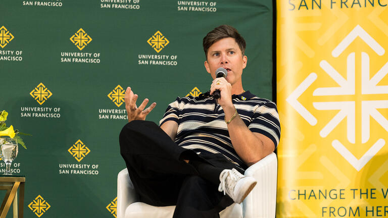 Colin Jost talking on stage at the Silk Speaker Series