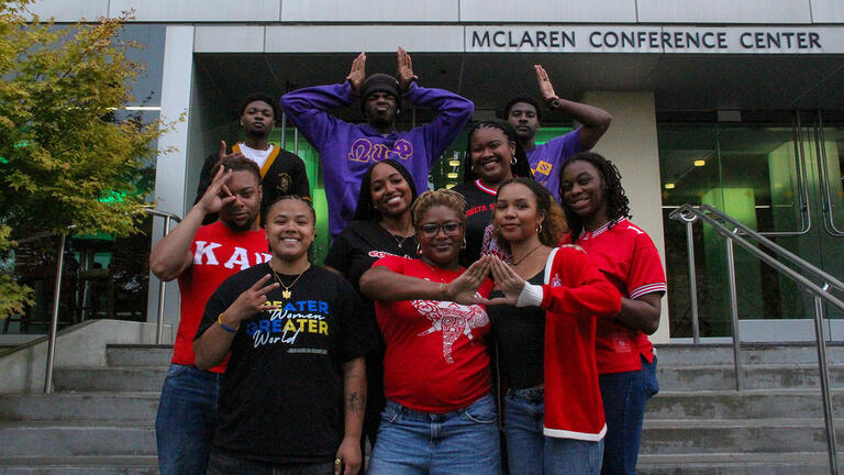 students from greek life pose together as a group in front of McClaren