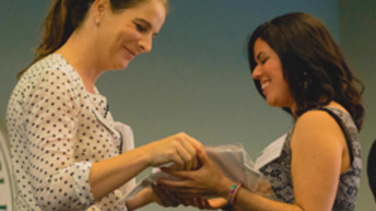 A student receives her award from Professor Carol Graham