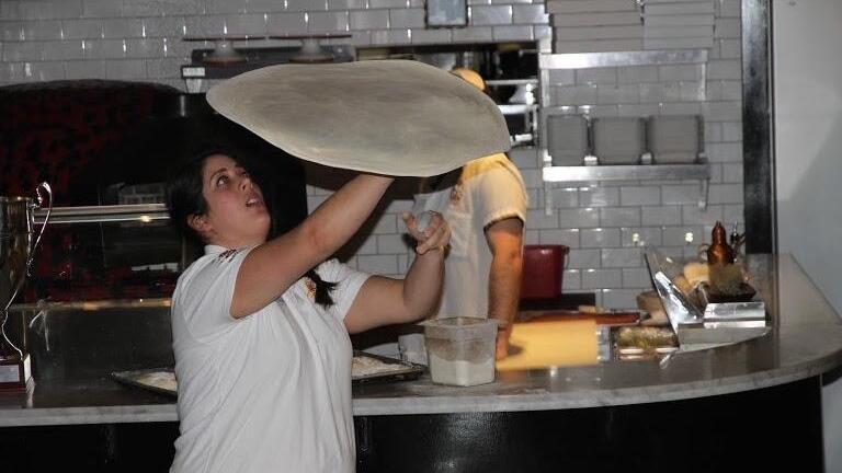 Laura Meyer tossing pizza