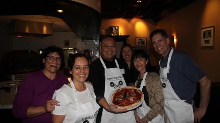 Students with chef holding pizza