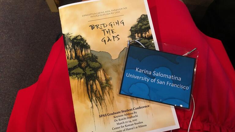 Program and student badge from 28th annual School of Pacific and Asian Studies Graduate Conference, at University of Hawai'i at Mānoa