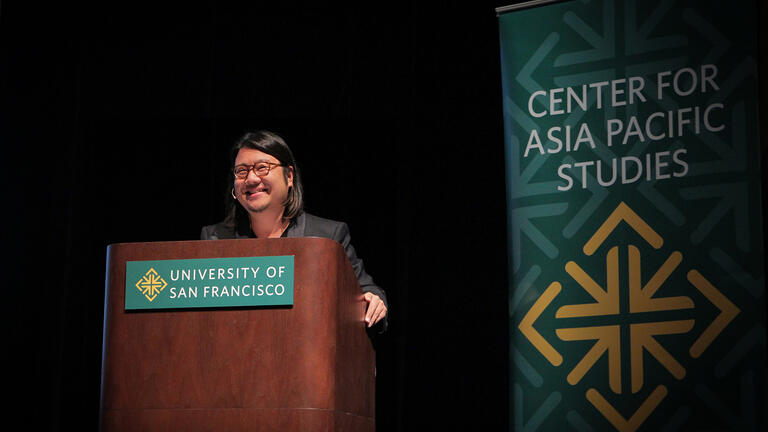 Kevin Kwan laughing at podium