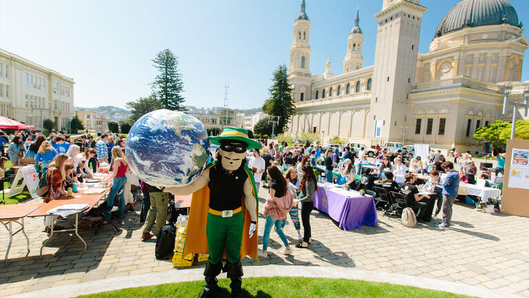 USF mascot Don Francisco holding a globe at our Earth Day celebration