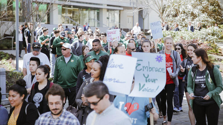 USFers holding signs and marching for Sexual Assault Awareness Month.