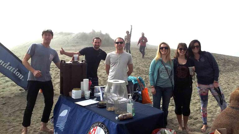 Volunteers at beach cleanup working to remove cigarette butt litter