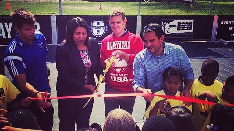 Rob Cann cutting ribbon at ceremony for I PLAY FOR SF adult soccer league benefiting Street Soccer USA, a nonprofit organization.