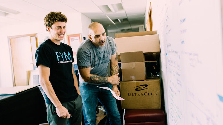 Kevin Clark '15 and Ray Bussolari '14 prepare an exhibit for the Foster Youth Museum. 