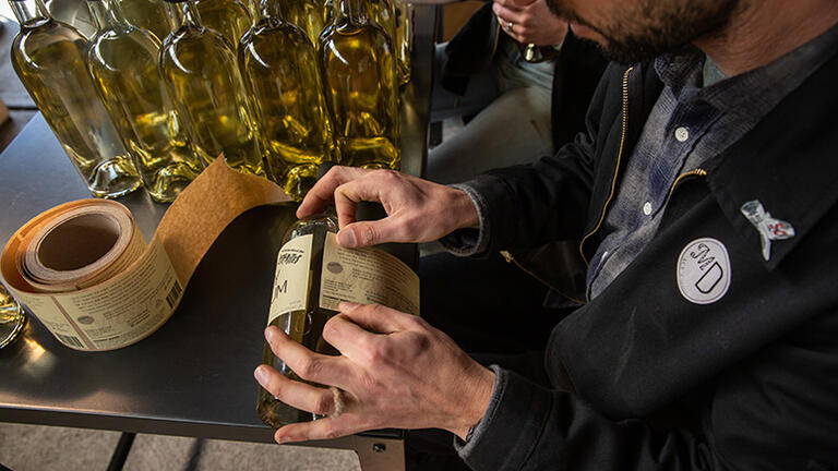 Jake putting a sticker on the whiskey bottle