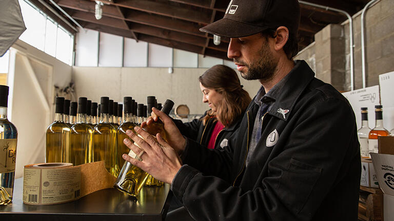 Therese Agnew and Jake Chevedden packaging whiskey bottles