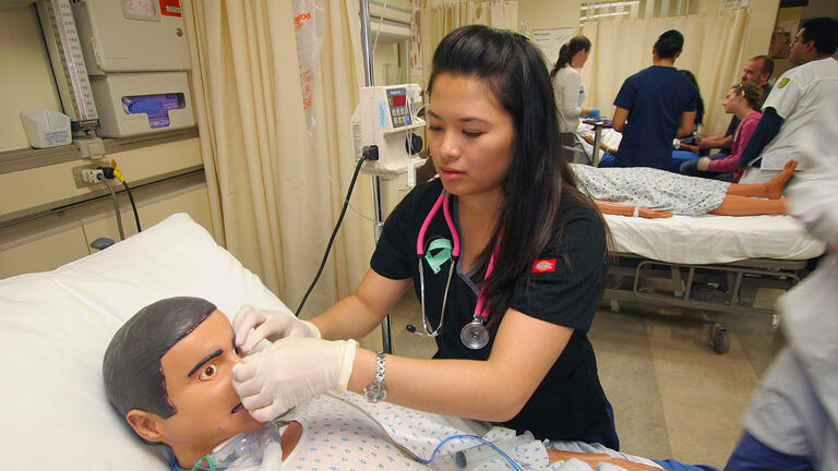 Students practicing on a mannequin in a simulation lab