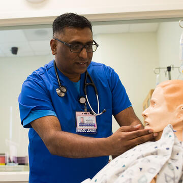 Vincent Samuel works on a dummy patient in the nursing simulation lab