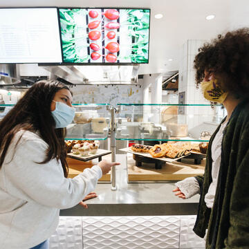 Two students select food at cafeteria.