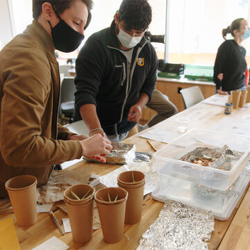 Students work together on an engineering project on a work table.