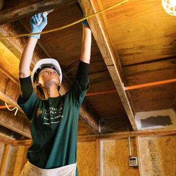 Student volunteering building a house