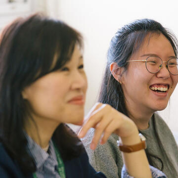 Two students smiling in class.